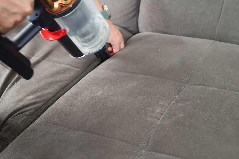 Crevice nozzle cleaning between the sofa cushions.